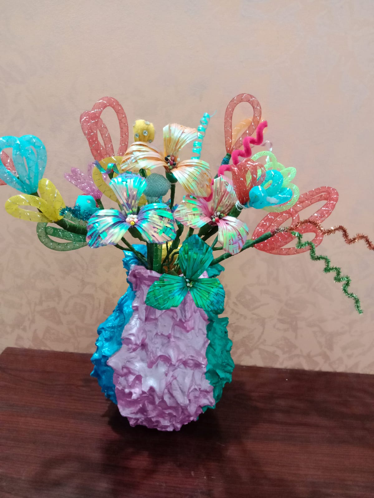 Handmade bright flowers displayed in a textured vase